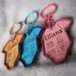 Porte‑clés naissance personnalisés gravure & découpe laser – différentes couleurs disponibles Porte‑clés bois bébé gravés avec prénoms et détails de naissance, disponibles en rose, bleu et couleur bois